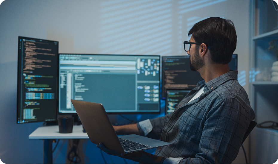 Developer analyzing code on monitors